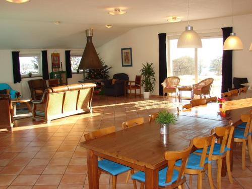 uma sala de estar com uma mesa de madeira e cadeiras em Groepsverblijf Snowview Lodge em Medendorf