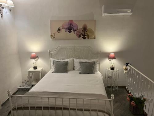ナポリにあるCasa Ornella Napoliのベッドルーム1室(白いベッド1台、ランプ2つ、ファン付)