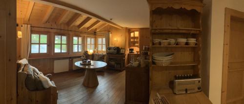een keuken met houten vloeren en een tafel in een kamer bij Le Chalet Hôtel Cordon Adults Only in Cordon