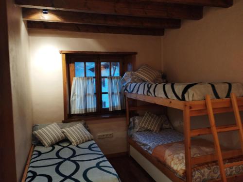 two bunk beds in a room with a window at Esquí, Aigüestortes y Boí-Taüll a tus pies en EbreHogar in Pla de l'Ermita