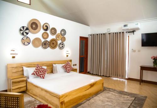 a bedroom with a bed with plates on the wall at Shose Farmhouse Chalets & Campsite in Moshi
