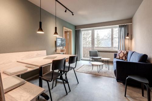 a living room with a table and chairs and a couch at Belmont- Apartment Haus in Arosa