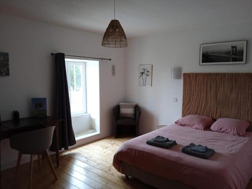 1 dormitorio con cama, escritorio y ventana en Le Cosy, en Hiersac