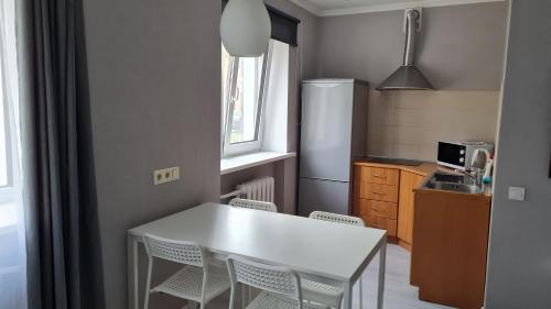 a small kitchen with a white table and chairs at Central Park in Daugavpils