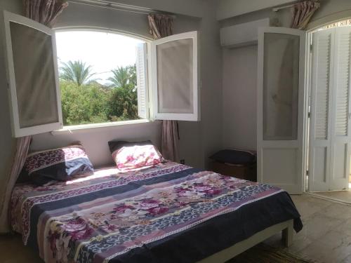 a bedroom with a bed and a large window at Blue holiday family summer villa - privé pool- AC- 5 bdr- 10 pax in Alexandria