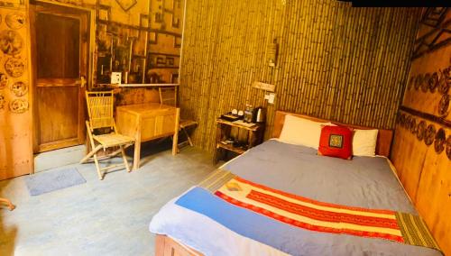 a bedroom with a bed and a desk and a chair at Little Yen's Homestay in Mèo Vạc