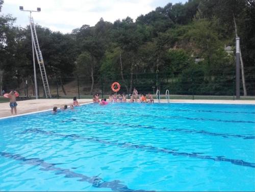 un grupo de personas en una gran piscina en Apartamento Cuca en Baralla
