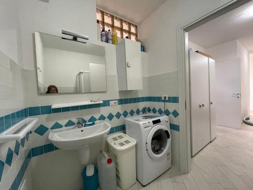 a bathroom with a washing machine and a sink at Le Verande di Isola Rossa in Isola Rossa