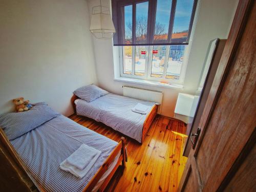 Cette petite chambre comprend 2 lits et une fenêtre. dans l'établissement Apartament Tuwim, à Przemyśl