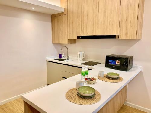 a kitchen with a counter with two plates and a microwave at Deco Home @ Aru Suites in Kota Kinabalu