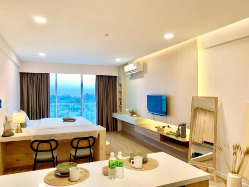 a hotel room with a bed and a television at Deco Home @ Aru Suites in Kota Kinabalu