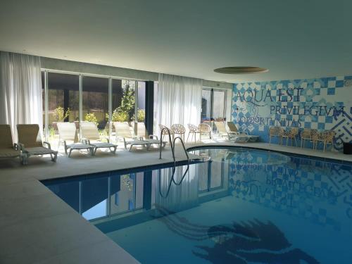 a swimming pool in a hotel with chairs and tables at HD | Duecitânia Design Hotel in Penela