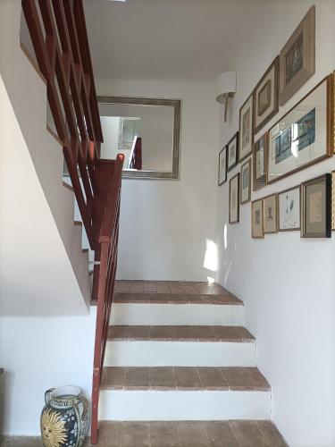 a staircase in a room with pictures on the wall at Casale Il Girasole in San Costanzo