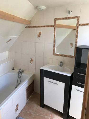 une salle de bain avec un lavabo, une baignoire et un miroir dans l'établissement Maisonnette au pied du Mont Dol, à Mont-Dol