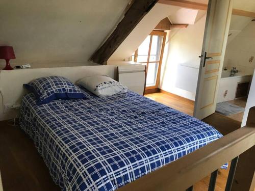 Un dormitorio con una cama azul y blanca y una ventana en Maisonnette au pied du Mont Dol, en Mont-Dol