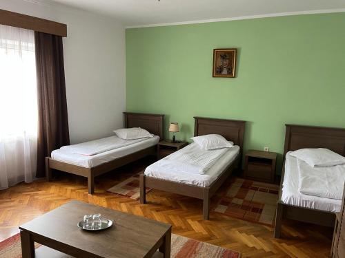 a room with two beds and a coffee table at Pensiunea Diana in Făgăraş