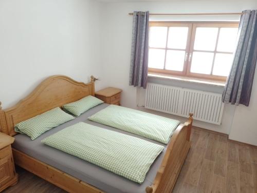 a bedroom with a bed and a window at Bio Berghof Langerlehen in Berchtesgaden