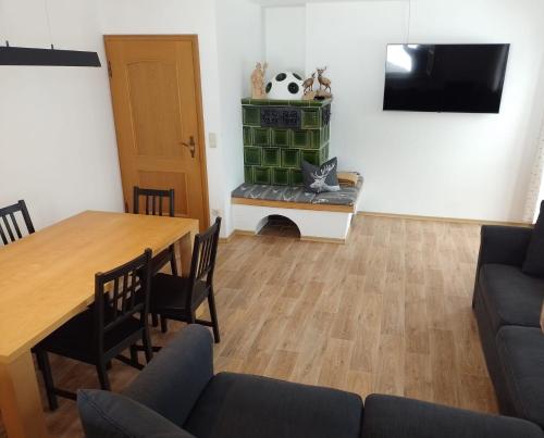 ein Wohnzimmer mit einem Tisch und einem TV in der Unterkunft Bio Berghof Langerlehen in Berchtesgaden