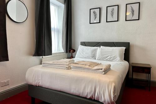 a bedroom with a bed with towels on it at The Derby Hotel in Barrow in Furness