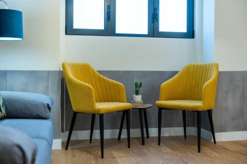 two yellow chairs and a table in a room at FLH Santa Cruz Triplex with Terrace in Santa Cruz