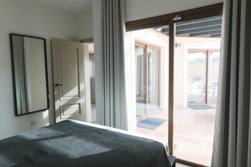 sypialnia z łóżkiem i przesuwnymi szklanymi drzwiami w obiekcie Moderne villa met verwarmd zwembad in Corralejo w Corralejo