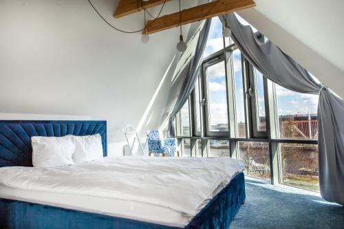 a bedroom with a bed and a large window at Space Apartments Old Town - River View in Szczecin