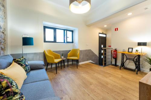 a living room with a blue couch and yellow chairs at FLH Santa Cruz Triplex with Terrace in Santa Cruz