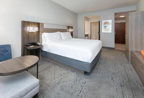 a hotel room with a bed and a chair at Holiday Inn Express & Suites - Dallas Park Central Northeast, an IHG Hotel in Dallas