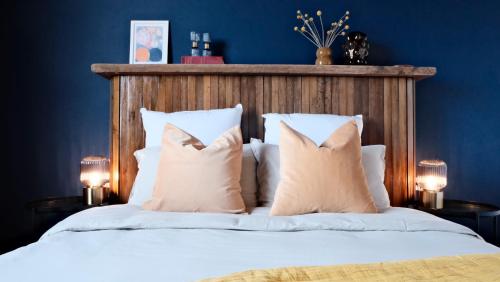 a bedroom with blue walls and a bed with pillows at Un air de campagne à Baudival in Le Cateau