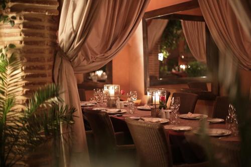 a dining room with a long table and chairs at La Maison Arabe Hotel, Spa & Cooking Workshops in Marrakech