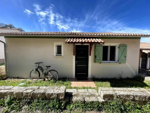 a bike parked in front of a small house at Maison au calme avec piscine et climatisation in Sollacaro