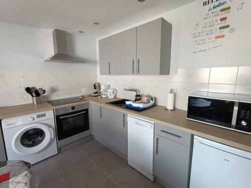 a kitchen with a sink and a washing machine at Le Hutteau in Vaudricourt