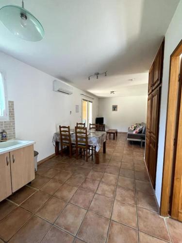 a kitchen and dining room with a table and chairs at Maison au calme avec piscine et climatisation in Sollacaro