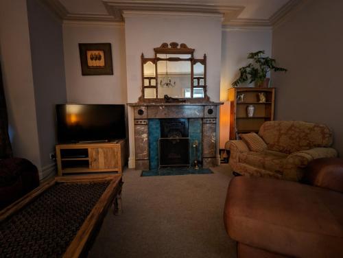 a living room with a fireplace and a television at 5BR townhouse Arnos Court Villa Bristol w parking in Bristol