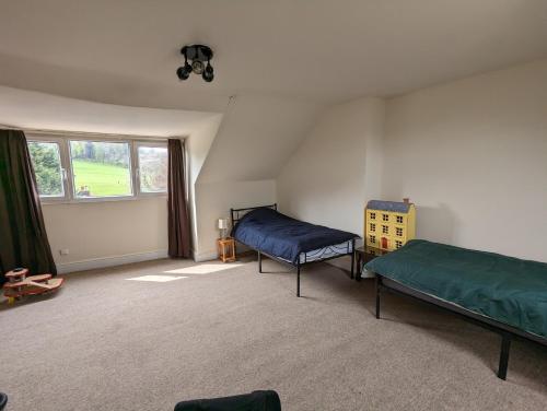 a room with two beds and a window at 5BR townhouse Arnos Court Villa Bristol w parking in Bristol