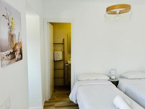 two beds in a room with white walls at Vilamarlux VII in Vilassar de Mar