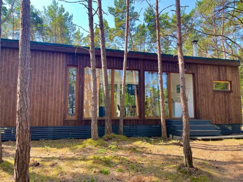 eine Holzhütte im Wald mit Bäumen in der Unterkunft BEACH HOUSE HUBERT in Undva