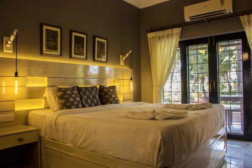 a bedroom with a large white bed and a window at LUISA BY THE SEA VILLAS in Cavelossim