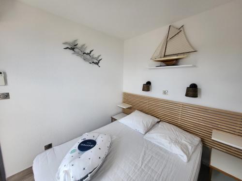 - une chambre avec un lit et un bateau sur le mur dans l'établissement Cap Esterel Appartement haut de gamme, à Saint-Raphaël