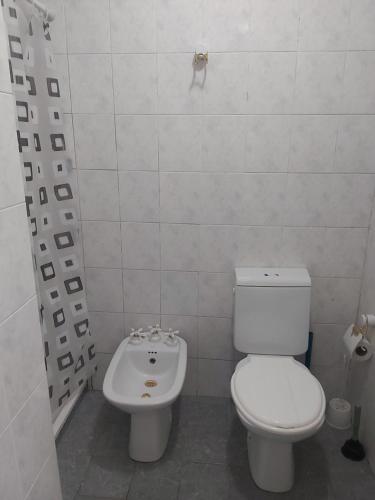 Baño blanco con aseo y lavamanos en Cerca de todo Habitaciones en Buenos Aires