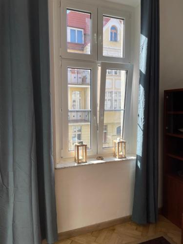 a window with two candles on a window sill at Apartamenty i pokoje przy sopockim molo in Sopot
