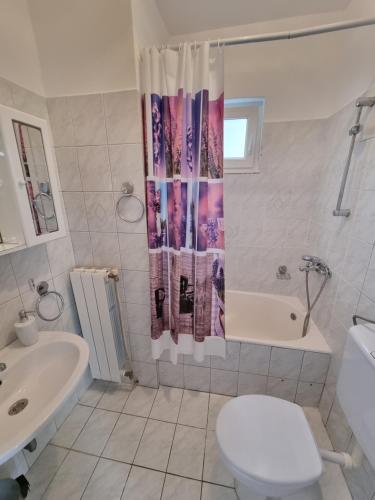 a bathroom with a toilet and a shower curtain at Kristina in Vrbnik