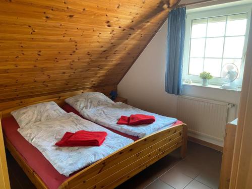 ein Schlafzimmer mit 2 Betten und roten Handtüchern darauf in der Unterkunft Ferienhaus Strandfuchs, Hooksiel in Wangerland