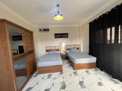 1 dormitorio con 2 camas y espejo en Nubian Villa with Private Pool en Naj‘ al Aḩwāl