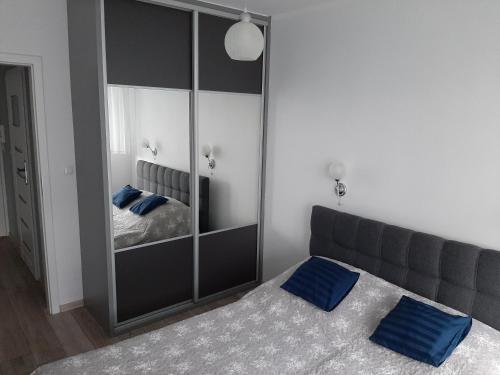 a bedroom with a bed and a large mirror at Apartament całoroczny Bliżej Morza in Kołobrzeg