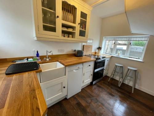 a kitchen with a sink and a stove at Cosy Coastal 2-Bedroom Cottage with Hot Tub and Log Burner in West Mersea
