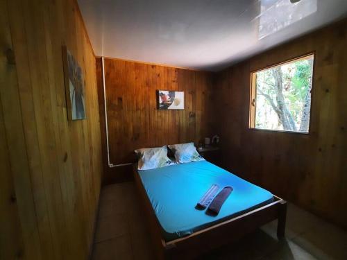 um pequeno quarto com uma cama e uma janela em La Caz à Irène em Saint-Joseph