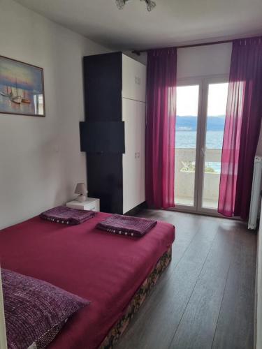 sypialnia z łóżkiem i oknem z widokiem na ocean w obiekcie Kristina w mieście Vrbnik
