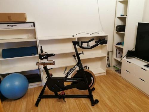 a room with a exercise bike and a television at Loghouse apartment in arctic wonderland! in Kvaløya