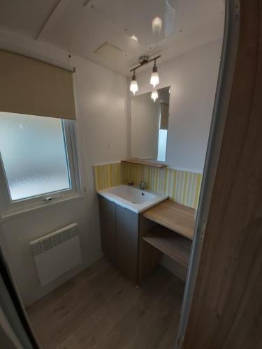 La salle de bains est pourvue d'un lavabo et d'un miroir. dans l'établissement Location mobile home 6 personnes a fréjus, à Fréjus